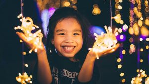 Little girl holding holiday lights